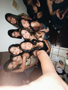 a group of young women standing next to each other in a room with white walls