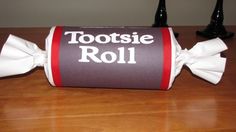 there is a roll wrapped in white paper with a bow on it that says tootsie roll