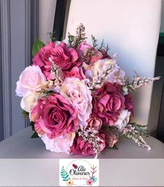 a bouquet of pink and white flowers sitting on top of a table