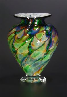 a colorful glass vase sitting on top of a table