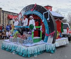 people are standing on top of a float with musical instruments and presents in the snow