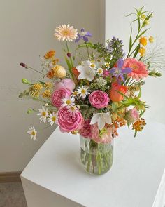 a vase filled with lots of different colored flowers