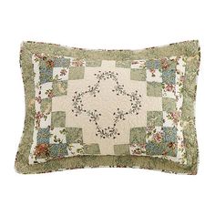 a green and white quilted pillow with flowers on it's side, sitting on a white surface