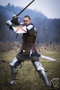 a man dressed in armor holding two swords