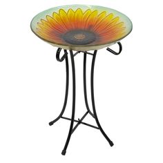 a glass table with a metal stand holding a sunflower design on the top and bottom