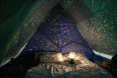 an image of a bed in a tent with stars on the ceiling and light shining through it