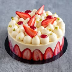 there is a cake with strawberries on top and white icing around the edges