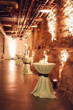 tables are set up in an old stone building with candles lit on the walls and around them