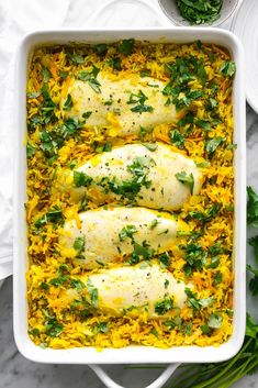 chicken and rice casserole in a white dish with parsley on the side