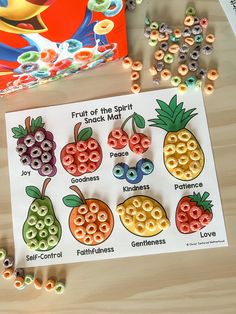 fruit of the spirit snack magnets and beads on a table next to a book