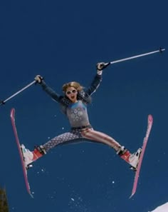 a woman flying through the air while riding skis