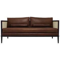 a brown leather couch sitting on top of a wooden frame