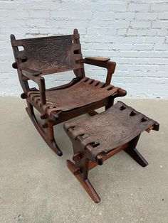 an old rocking chair and foot stool made out of wood with carvings on the seat