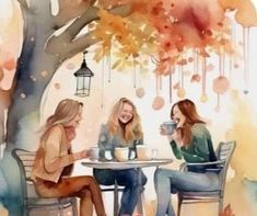 three women sitting at a table talking to each other in front of a tree with hanging lights