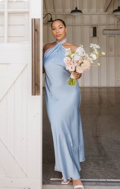 a woman in a blue dress holding flowers