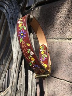 a wooden fence with a flowered belt hanging from it's side