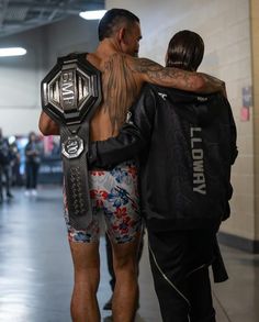 a man with his back turned to the camera, holding onto another man's shoulders