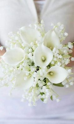 a bride holding a bouquet of white flowers