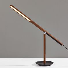 a wooden table lamp with a dim light on it's side and a black base