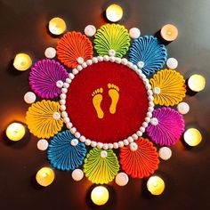 a colorful decoration with candles around it and a person's foot in the center