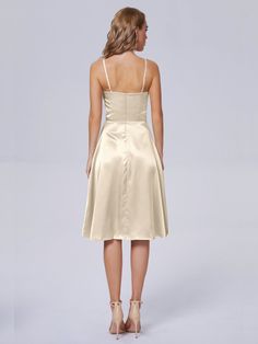 the back of a woman wearing a short champagne colored bridesmaid dress with spaghetti straps