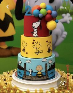 a three tiered cake decorated with peanuts and charlie the pooh characters on it