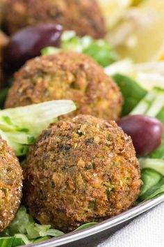 some meatballs are on a plate with lettuce and grapes