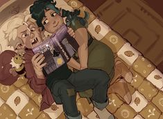 two people laying on a bed reading a book