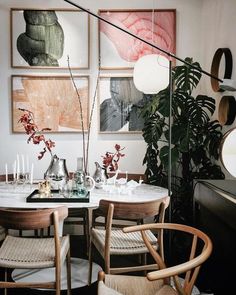 an image of a dining room with art on the wall and pictures hanging above it