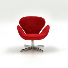 a red chair sitting on top of a metal base