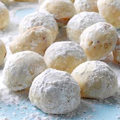 powdered sugar covered donuts on a blue surface