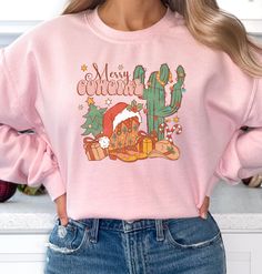 "🤠 With our Western Cowgirl Christmas sweatshirt, you can sleigh the holiday season. This cowboy or cowgirl Christmas classic is perfect for those who love a little country charm with their holiday cheer. 🌵🎄 🎅 Santa's gone western Christmas with cowboy twist that'll have you saying, \"Ho-ho-howdy!\" 🤣 This unisex crewneck sweatshirt is the perfect stocking stuffer for all the ranchers and rodeo lovers in your life. Whether you're dashing through the snow or just chilling by the fire, this r Gingerbread Cowboy, Cowgirl Christmas, Santa Sweater, Christmas Tree Sweater, Ugly Xmas Sweater, Tree Sweater, Dashing Through The Snow, Holiday Apparel, Christmas Classic