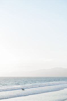 two surfers are riding the waves on their surfboards in the water at the beach