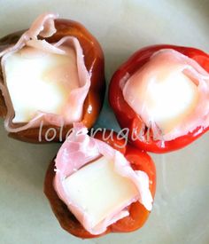 three stuffed peppers with cheese on them sitting on a plate