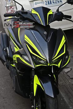 a black and yellow motorcycle parked next to a white car