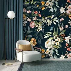 a living room with floral wallpaper and a chair in front of the curtained window