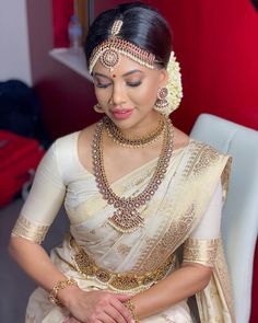 a woman in a white sari with gold jewelry