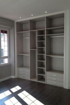 an empty room with white shelves and wooden floors