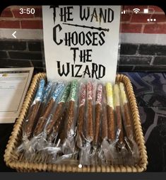 a basket filled with lots of different colored crayons next to a sign that says the wand chooses the wizard