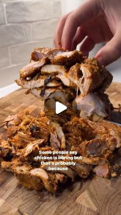 someone is cutting up some meat on a wooden board with the words chicken in being cut into pieces