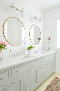 a bathroom with two sinks, mirrors and lights on the wall next to each other