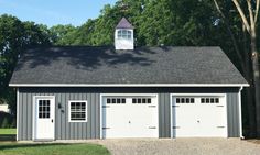 a garage with two doors and a steeple on the top floor is shown in front of some trees