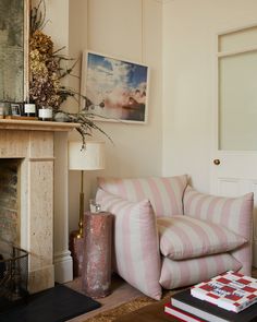 a living room filled with furniture and a fire place in front of a painting on the wall