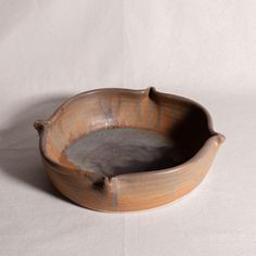 a brown bowl sitting on top of a white table