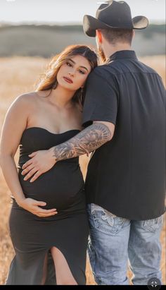 a pregnant woman in a black dress and cowboy hat is standing next to a man