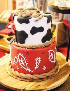 three tiered cake decorated with black and white cow print