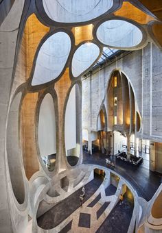 the interior of a modern building with circular windows and concrete arches on the ceiling, as seen from above