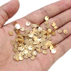 gold plated metal buttons are being held in someone's hand with the size