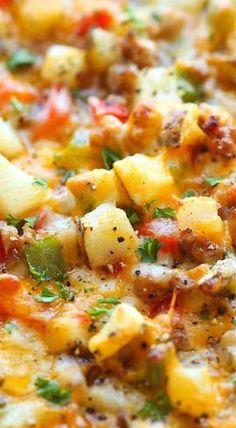 a casserole dish with potatoes, tomatoes and meat in it on a red plate