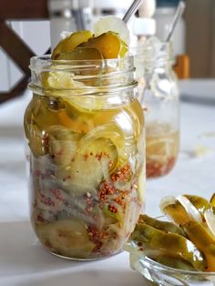 the best spicy bread and butter pickles in a mason jar with lemons, pepper sprinkled on top